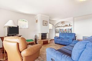 a living room with blue furniture and a tv at Villa Lucio in La Londe-les-Maures