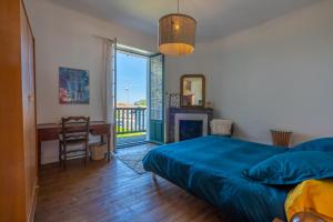 a bedroom with a bed and a desk and a window at Belle villa basque in Anglet