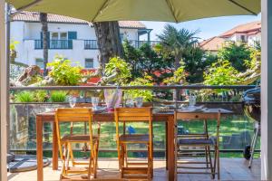 a table with chairs and an umbrella on a patio at Belle villa basque in Anglet
