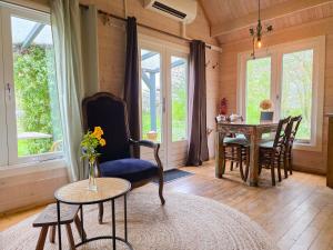 a living room with a table and chairs and windows at Vakantiewoning Moerweie GR04 in Grijpskerke