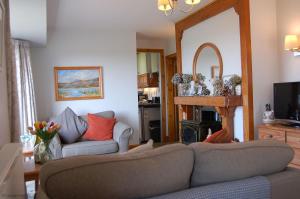 a living room with a couch and a mirror at Bryn Rhedyn Fairbourne in Fairbourne