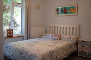 a bedroom with a bed and a window at Bryn Rhedyn Fairbourne in Fairbourne