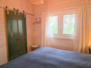 a bedroom with a green cabinet and a window at Vakantiewoning Moerweie GR04 in Grijpskerke