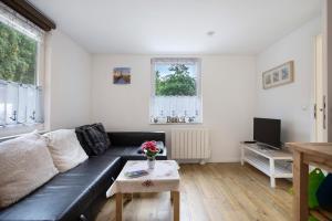 a living room with a black couch and a table at Bungalow Schoner Greif, Bgl 8 in Dranske