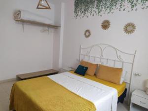 a bedroom with a bed with a yellow and white blanket at Cerca plaza de Toros Vera in Vera