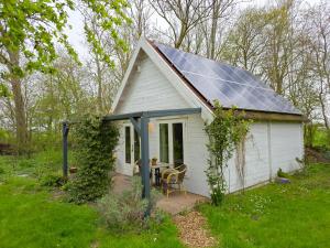 a small white house with a solar roof at Vakantiewoning Moerweie GR04 in Grijpskerke