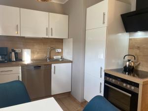 a small kitchen with white cabinets and a sink at Glückshuuske Sauerland in Meschede