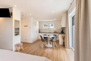 a room with a kitchen and a table and chairs at Fewo Parkside S2 - 8Min Legoland in Günzburg