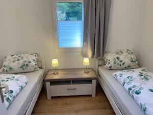 a room with two beds and a table with two lamps at Glückshuuske Sauerland in Meschede