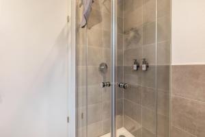 a shower stall with a glass shower door at Fewo Parkside S2 - 8Min Legoland in Günzburg +16 photos