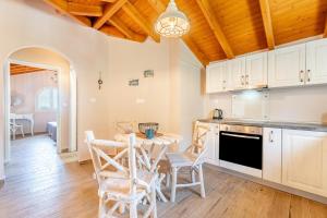 a kitchen with white cabinets and a table and chairs at Villa Konstantina Lulas Penthouse in Petrití +14 photos