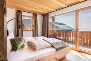 a bedroom with a bed and a large window at Feichterhof in San Genesio Atesino