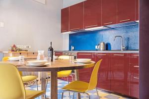 a kitchen with a wooden table and yellow chairs at Cadepaia Lago Maggiore in Laveno-Mombello +12 photos