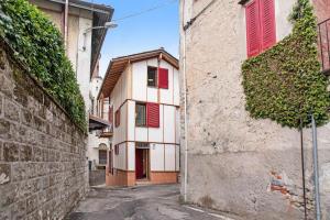 an alley with red shutters on a building at Cadepaia Lago Maggiore in Laveno-Mombello