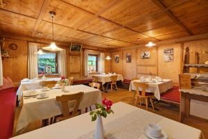 a restaurant with white tables and chairs and wooden ceilings at Bed and Breakfast Ederhof in San Giacomo