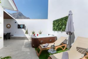 a bathroom with a tub and a table and an umbrella at Rincón de la Fontana in San Nicolás