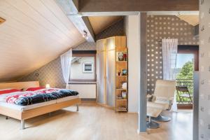 a bedroom with a bed and a chair in a room at Elkes Ferienappartment in Eschenrod