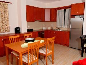 a kitchen with a wooden table with chairs and a refrigerator at Sami Beach Villas Thalia in Sami