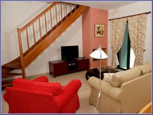 a living room with a red chair and a couch at Sami Beach Villas Thalia in Sami