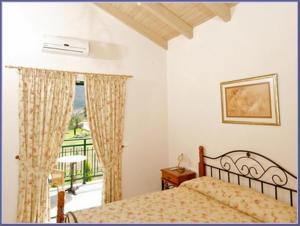 a bedroom with a bed and a balcony at Sami Beach Villas Thalia in Sami +28 photos