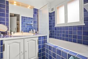 a blue tiled bathroom with a sink and a tub at Hébergement Climatisée Cogolin in Cogolin +13 photos