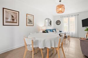 a living room with a white table and chairs at Hébergement Climatisée Cogolin in Cogolin
