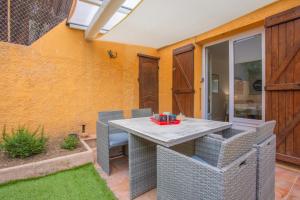 a patio with a table and chairs in a yard at Hébergement Climatisée Cogolin in Cogolin