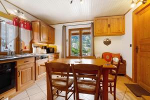 a kitchen with wooden cabinets and a table and chairs at Chez Stephane et Estelle in Villarodin-Bourget