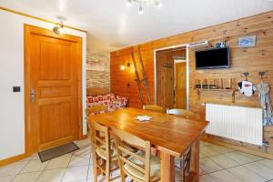 a dining room with a wooden table and a tv at Chez Stephane et Estelle in Villarodin-Bourget
