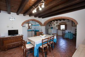a kitchen and dining room with a table and chairs at Sa Domedda in Orosei