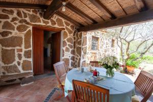 a table with a blue table cloth on a patio at Sa Domedda in Orosei +13 photos