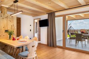 a dining room and living room with a table and chairs at Feichterhof in San Genesio Atesino