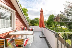 a balcony with a table and an umbrella at Gästehaus Elke Jensen in Langenhorn