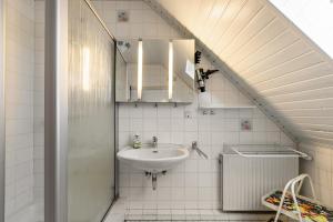a bathroom with a sink and a mirror at Gästehaus Elke Jensen in Langenhorn +43 photos