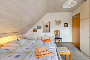 a bedroom with a bed and a chair at Gästehaus Elke Jensen in Langenhorn