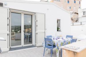a patio with a table and chairs and a balcony at Sunset Dimora in Siculiana Marina