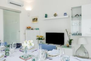 a dining room with a table with glasses and a television at Sunset Dimora in Siculiana Marina