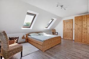 a bedroom with a bed and a chair and a window at Ferienwohnung Fraulund in Rügge