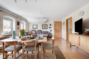 a kitchen and living room with a table and chairs at Ferienwohnung Fraulund in Rügge