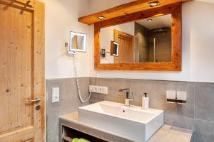 a bathroom with a sink and a mirror at Haus Alpenquelle Seeblick in Bad Kohlgrub +20 photos