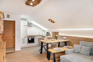 a kitchen and living room with a table and a couch at Haus Alpenquelle Seeblick in Bad Kohlgrub