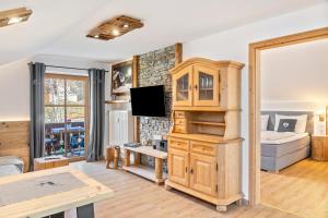 a living room with a tv and a couch at Haus Alpenquelle Seeblick in Bad Kohlgrub