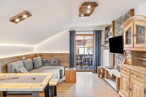 a living room with a couch and a table at Haus Alpenquelle Seeblick in Bad Kohlgrub