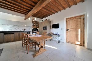 a large kitchen with a wooden table and chairs at La maison Poulogne in Capvern