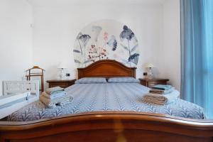 a bedroom with a large wooden bed with towels on it at Casa Elli in Osio Sotto