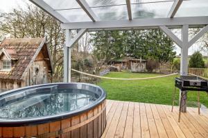 a hot tub on a deck with a grill at Vroni in Ebersbach-Musbach