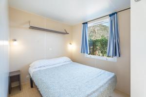 a small bedroom with a bed and a window at Falaguera Bungalow 2 in Bárig +18 photos