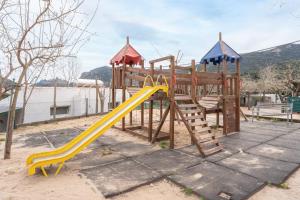 a wooden playground with a slide and a slideintend at Falaguera Bungalow 2 in Bárig