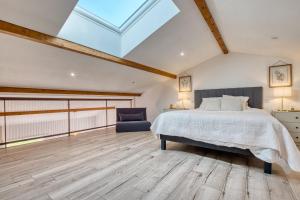 a attic bedroom with a bed and a chair at Le Refuge des Vignes in Lamonzie-Saint-Martin