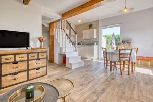 a kitchen and living room with a table and a television at Le Refuge des Vignes in Lamonzie-Saint-Martin